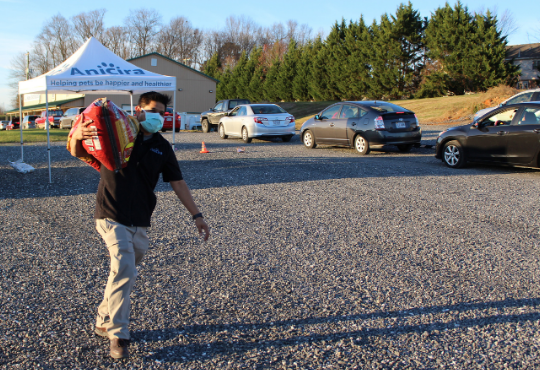 Dan carries a large bag of dog food on his shoulder